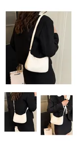 Detail view of white crescent shoulder bag with golden zipper and synthetic leather texture