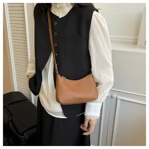 Detailed view of a brown minimalist half-moon crossbody bag with adjustable strap