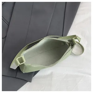 Top view of light green underarm bag showing zipper closure and gray interior lining