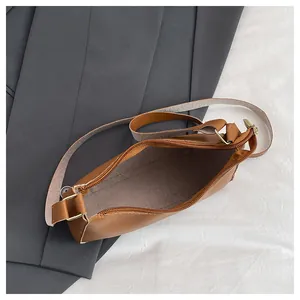Interior view showing the large capacity and zipper closure of the brown leather shoulder bag