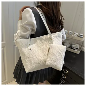 Close-up of white woven tote bag texture with metal rivets and matching mini pouch bag