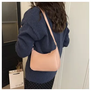 Rear view of a pink PU leather hobo bag worn by a model to show size and fit