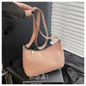 Close-up of a pink PU leather baguette bag with a gold zipper and fine texture