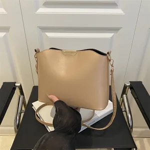 Minimalist khaki shoulder bag with gold metal trim and strap for women in 2025