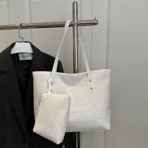 White woven tote bag with matching pouch on metal hanger with minimalist black suit background
