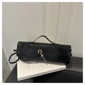 Détail du sac en cuir noir motif crocodile avec boucle en métal doré hexagonal