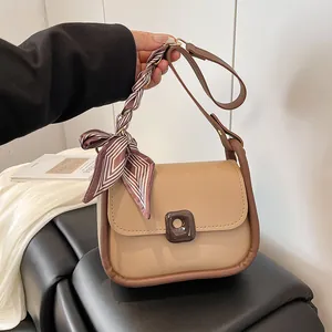 Minimalist beige crossbody bag with brown trim and purple striped silk scarf handle