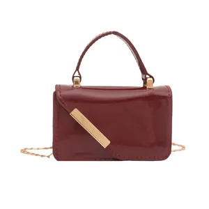 Glossy burgundy red rectangle flap handbag with gold metal bar and chain strap