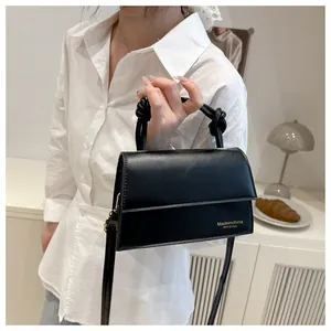 Detail einer schwarzen minimalistischen Handtasche mit einem einzigartigen Knotengriff