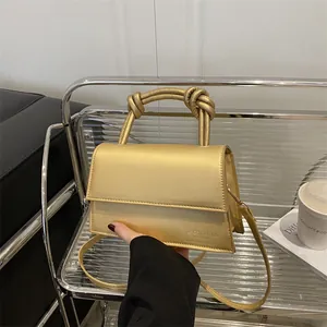 Metallische goldene Umhängetasche mit Knotengriffen und elegantem rechteckigem Design