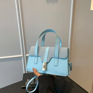 Blue contrasting leather and fabric tote bag with adjustable shoulder strap and metal clasp