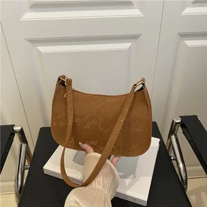 Stylish brown snake pattern crossbody bag with golden rings and a sleek minimalist design