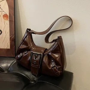 Sac bandoulière marron foncé en cuir brillant avec boucle vintage et design demi-lune