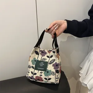 Floral canvas shoulder bag with Living Traveling Share label and black handles