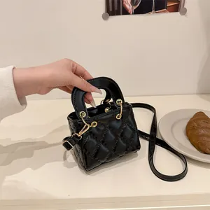 Mini sac à main en cuir verni noir à surpiqûres matelassées et détails dorés chics