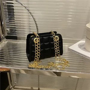 Classic black quilted shoulder bag with gold chain strap on minimalist display