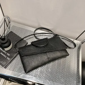 Elegante borsa a mano nera texture coccodrillo con manico rotondo e tracolla