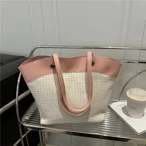 Sac fourre-tout minimaliste en paille crème avec garniture en cuir rose pour la plage
