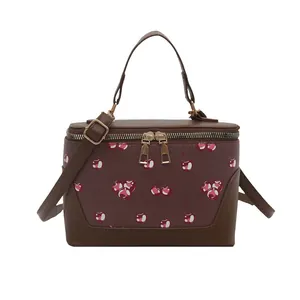 Brown vintage handbag with cherry print, dual zipper closure and adjustable shoulder strap