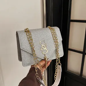 Silver sequin crossbody bag with gold chain strap and stylish metallic S logo
