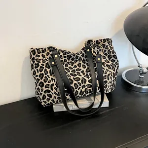 Fashionable leopard print large tote bag with black handles and metal ring detail