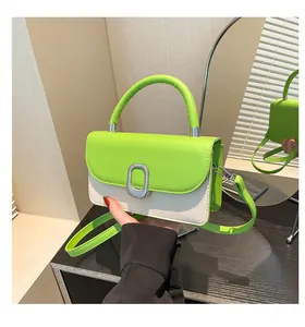 Detail of vibrant green leather flap and cream textured fabric on square crossbody bag