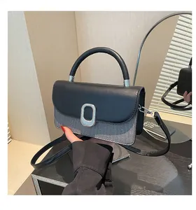 Detail of tweed and leather crossbody bag with silver oval metal buckle and handle