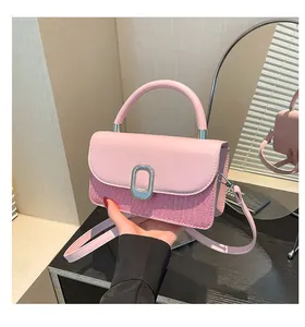 Detail of pink patchwork handbag featuring silver buckle and adjustable shoulder strap