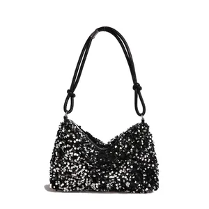 Chic silver sequin shoulder bag with black knotted handles and zipper closure