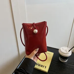 Mini sac pour téléphone rouge verni avec bouton perle et fine bandoulière