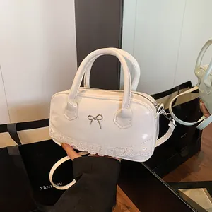 White patent leather Boston bag with metal bow and lace trim, sweet ballet style