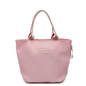 Minimalist light pink fabric handbag with zipper closure and fashion label for women