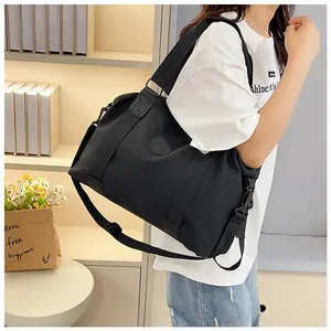 Close-up of black gym bag with durable nylon texture, round logo, and adjustable strap