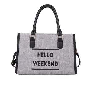 Bolso tote de lona gris con ribete de cuero negro y texto HELLO WEEKEND sobre blanco