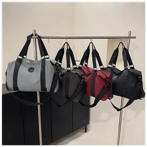 Detail view of multi-color water-resistant nylon travel bags in gray, brown, red and black