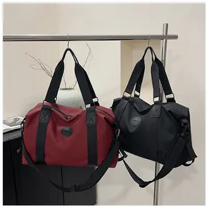 Detail of durable nylon fitness bags in burgundy and black with adjustable shoulder straps
