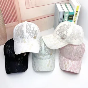 Detail of lace baseball caps with floral patterns and metal M logo in various colors