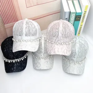 Detailed view of lace baseball caps with sequins and faux pearl rhinestone chains