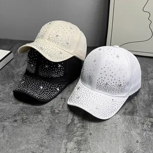 Three stylish baseball caps with rhinestone star patterns on grey textured surface