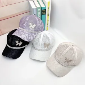 Detailed display of four lace baseball caps with rhinestone butterflies in multi-color