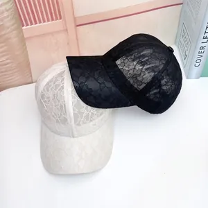 Detail of delicate floral lace baseball caps in black and white with breathable mesh texture