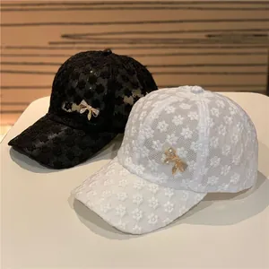 Lace floral baseball caps with metal bow accents in black and white colors