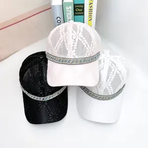Detailed view of lace mesh baseball caps with sparkling rhinestone and bead decorations