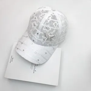 Close-up of intricate white lace pattern and sparkling butterfly rhinestone on the cap
