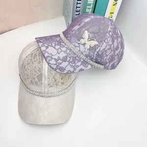 Detailed view of lace baseball caps with rhinestone butterfly and shiny studded brims