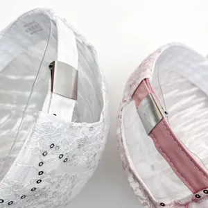 Detailed close-up of adjustable metal buckle on sequin lace baseball caps in white and pink