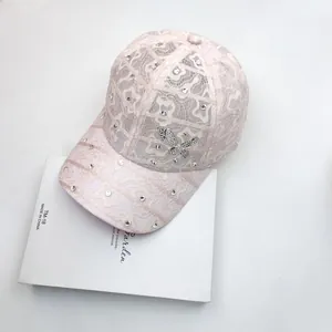 Detailed close-up of a pink lace baseball cap with shimmering rhinestones and a bow knot