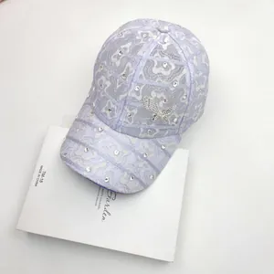 Detail of lavender lace baseball cap with sparkling rhinestones and a 3D butterfly patch