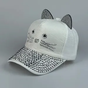 Dettaglio del gatto in strass e orecchie 3D su cappellino da baseball bianco