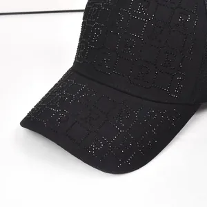 Detailed close-up of luxury black baseball cap featuring rhinestone letter B monogram